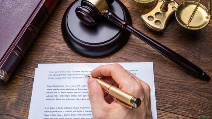 Writing a will with a court hammer, symbolizing estate planning for NRIs